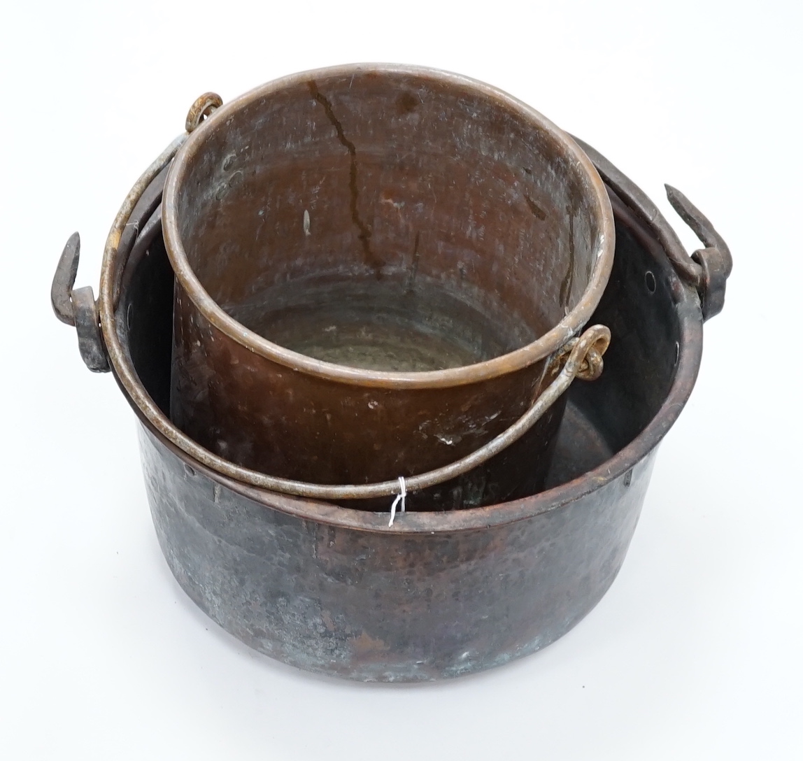 Two copper cauldrons with swing handles, the largest 43cm wide